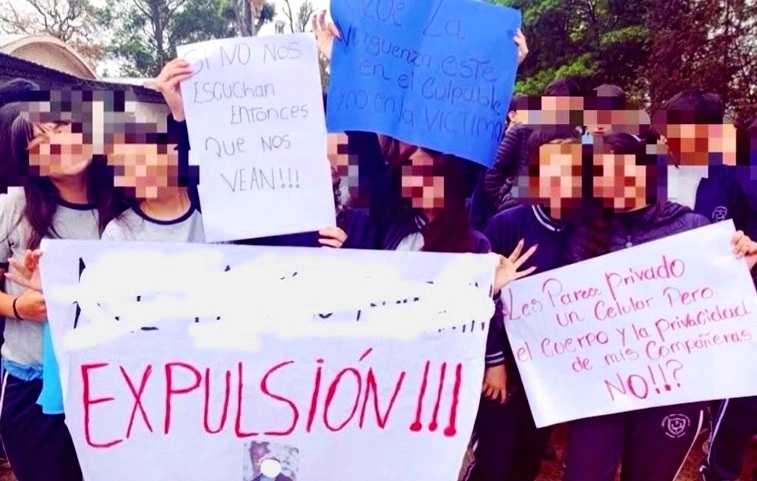 Estudiantes con los rostros pixelados muestran carteles de reclamo